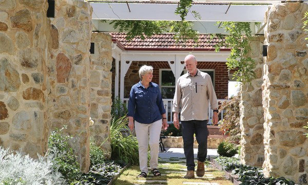  Paul Kitto and Ruth Shepherd stroll beneath one of two grand stone arbours in their expansive Hills garden.