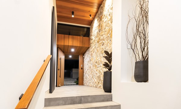 Timber and sandstone are used to create a stunning entrance in the eastern suburbs home of architect Anthony Donarto who teamed up with builder Vin Melisi & Son to create a resort-like home for him and his family. With clean design, spaciousness and flow, the home was judged the 2022 HIA South Australian Custom Built Home of the Year.