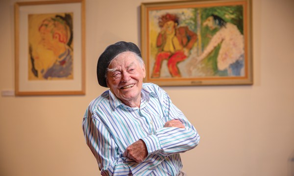 David Dridan in front of artworks from his private collection, painted by the late Barry Humphries. They are now on display for the first time in the exhibition, By Barry Humphries: From the David Dridan Family Collection, in the foyer of the Festival Theatre. 