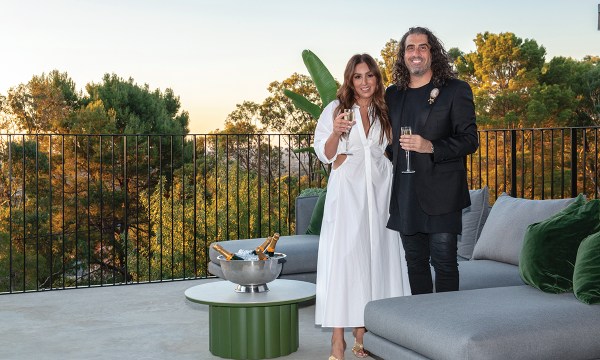 Adriana and Damien relax with a glass of Champagne on their Beaumont balcony before guests arrive.