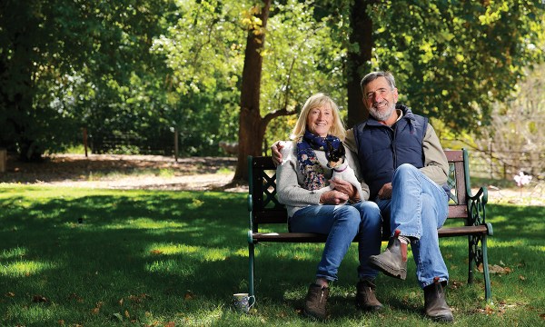 Jane and Hans Leidig pictured with dog Issy in the shade of their ancient trees.