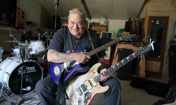 Rob Riley in his studio at home with two favourite guitars - he's used a Holden Kingswood badge to decorate their headstocks.